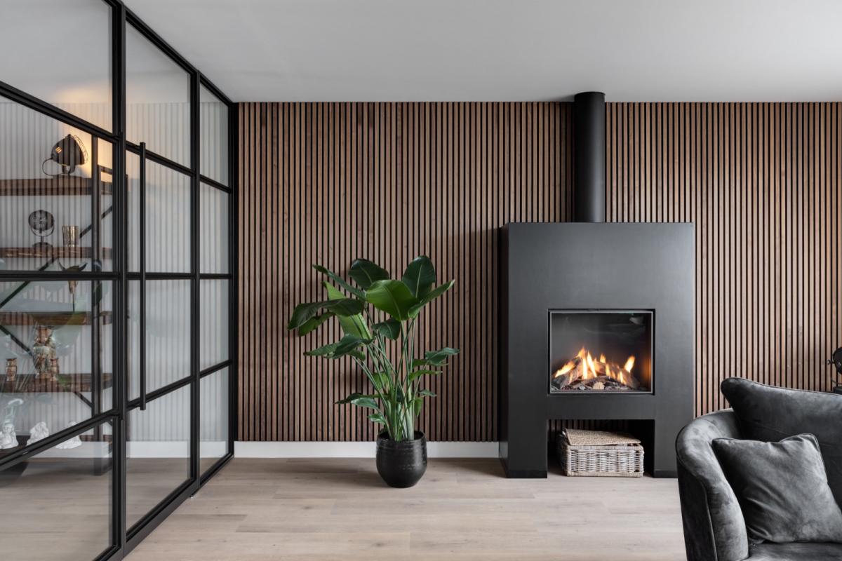 woonkamer met haard en stalen deuren