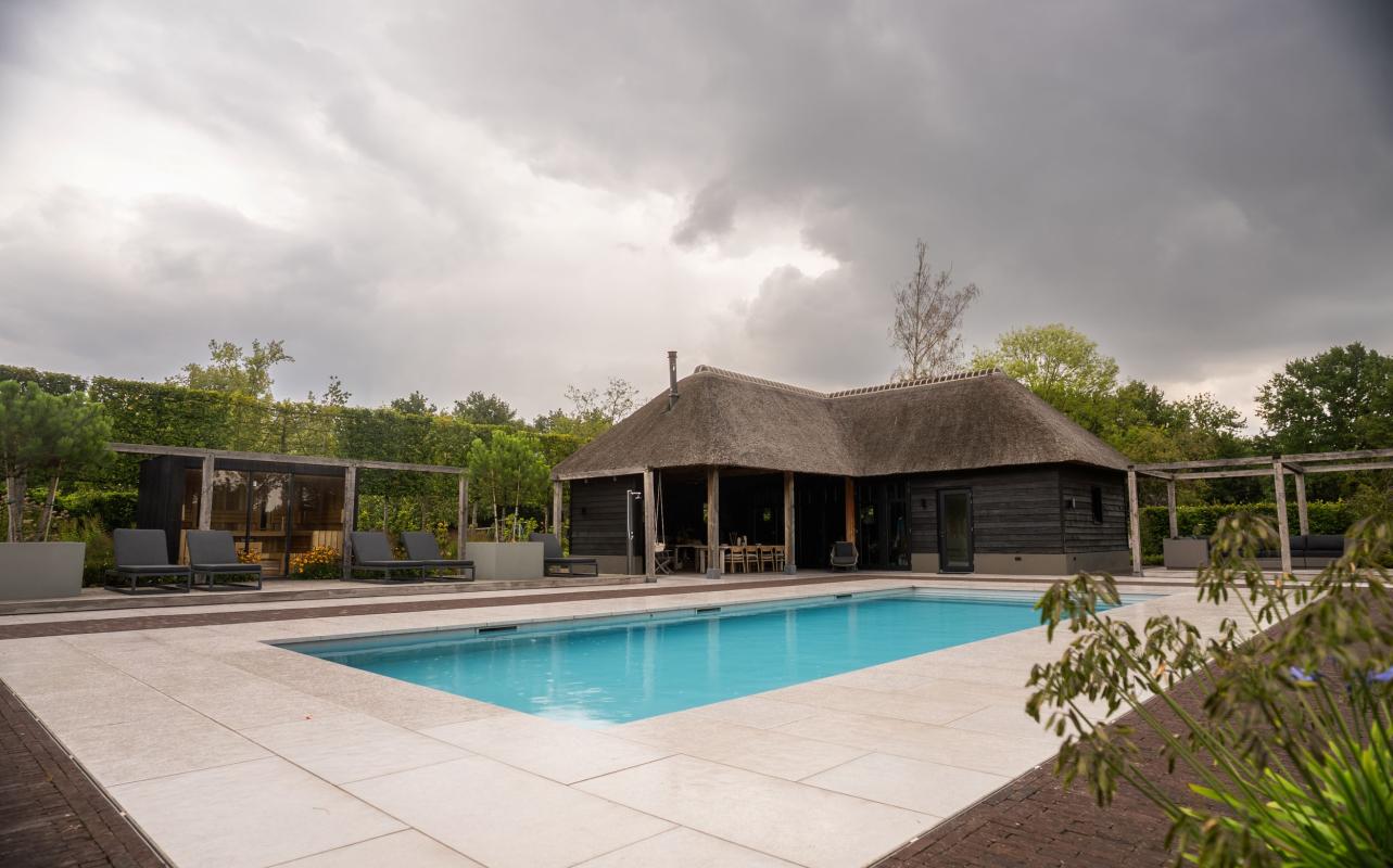 luxe tuin met zwembad en poolhouse