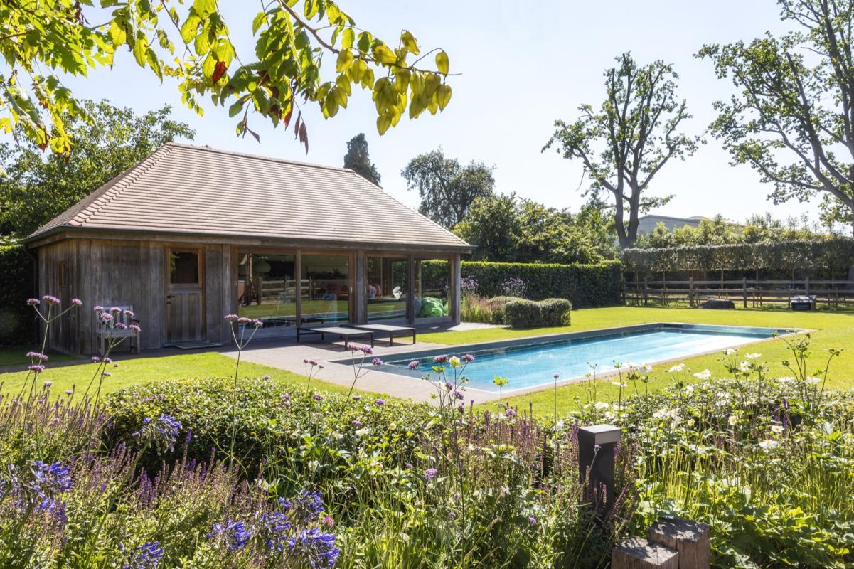 tuin met luxe zwembad en poolhouse