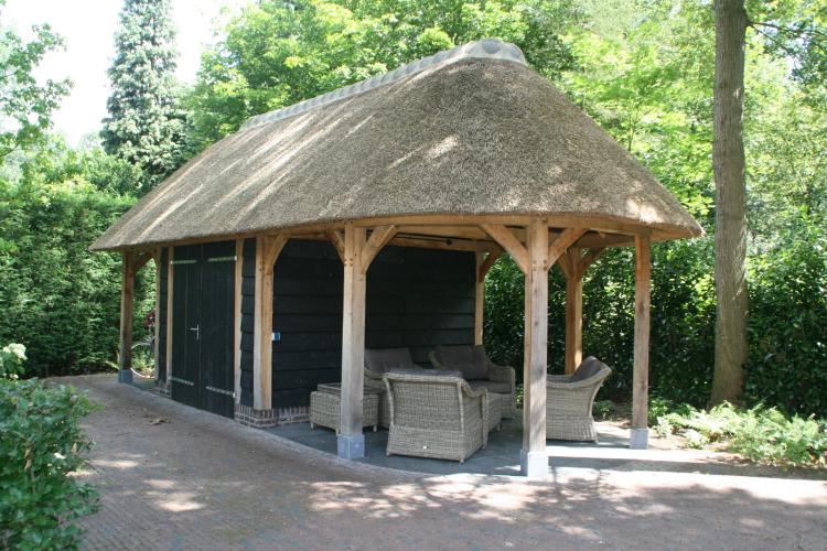 Houten bijgebouw met rieten kap