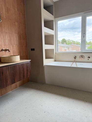 Exclusieve badkamer met luxe Cemher microcement wandafwerking