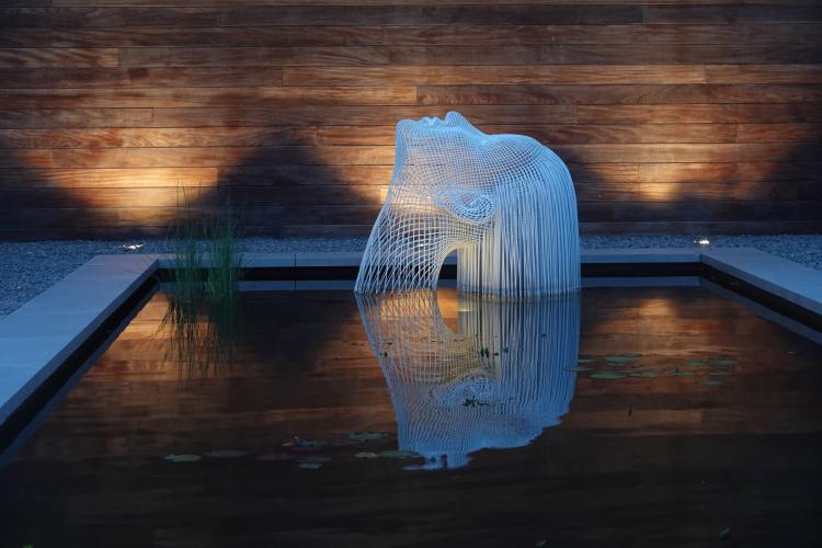 Strakke tuin met kunst en grote vijver