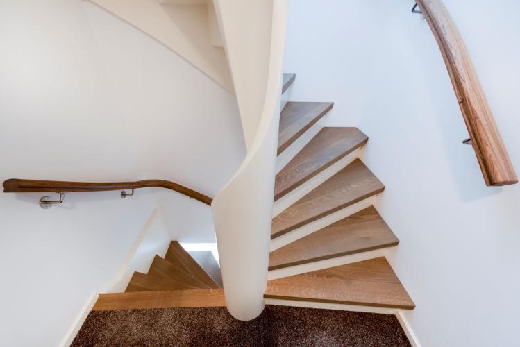 Massief eiken trap met gebogen spil in luxe interieur
