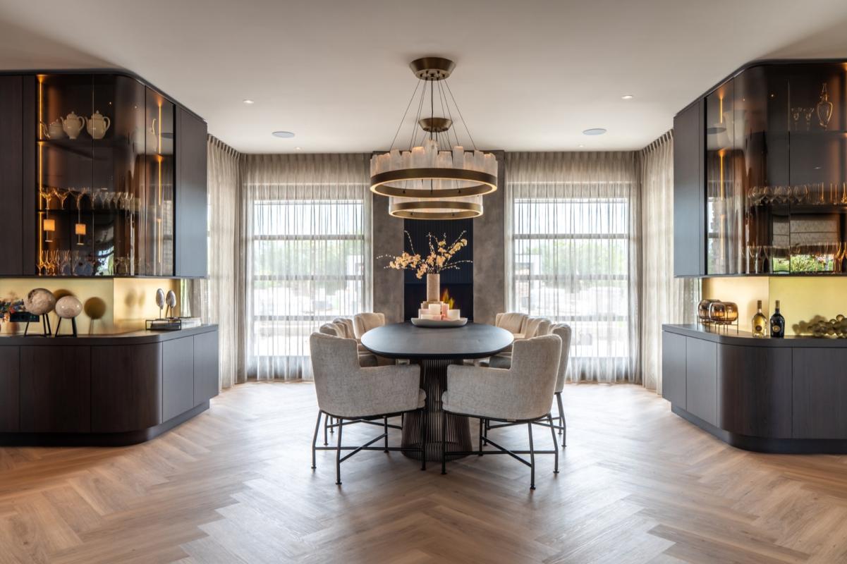 Eetkamer met luxe wandafwerking en haard Liquid Metal kleur brons