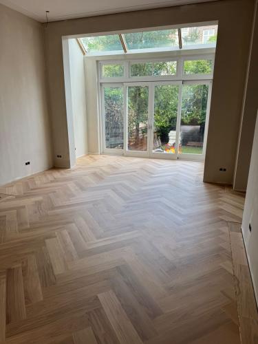 Eiken Visgraat parket (140 x 700 mm) met luxe messing bies – Amsterdam