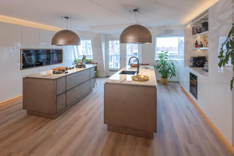 Luxe maatwerk keuken met bronzen details en dubbele eilanden in Rotterdam