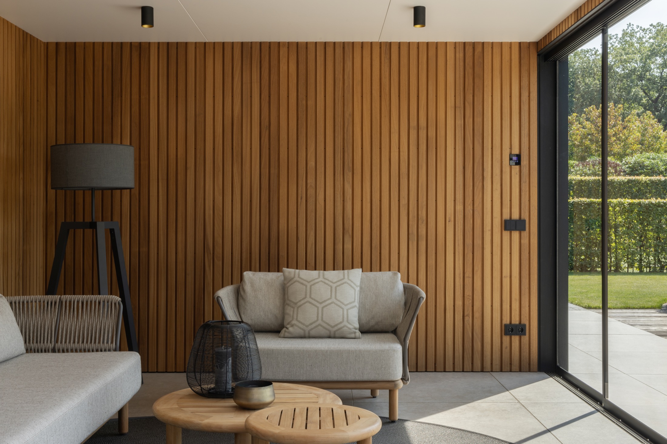tuin met luxe overkapping met glazen schuifdeuren