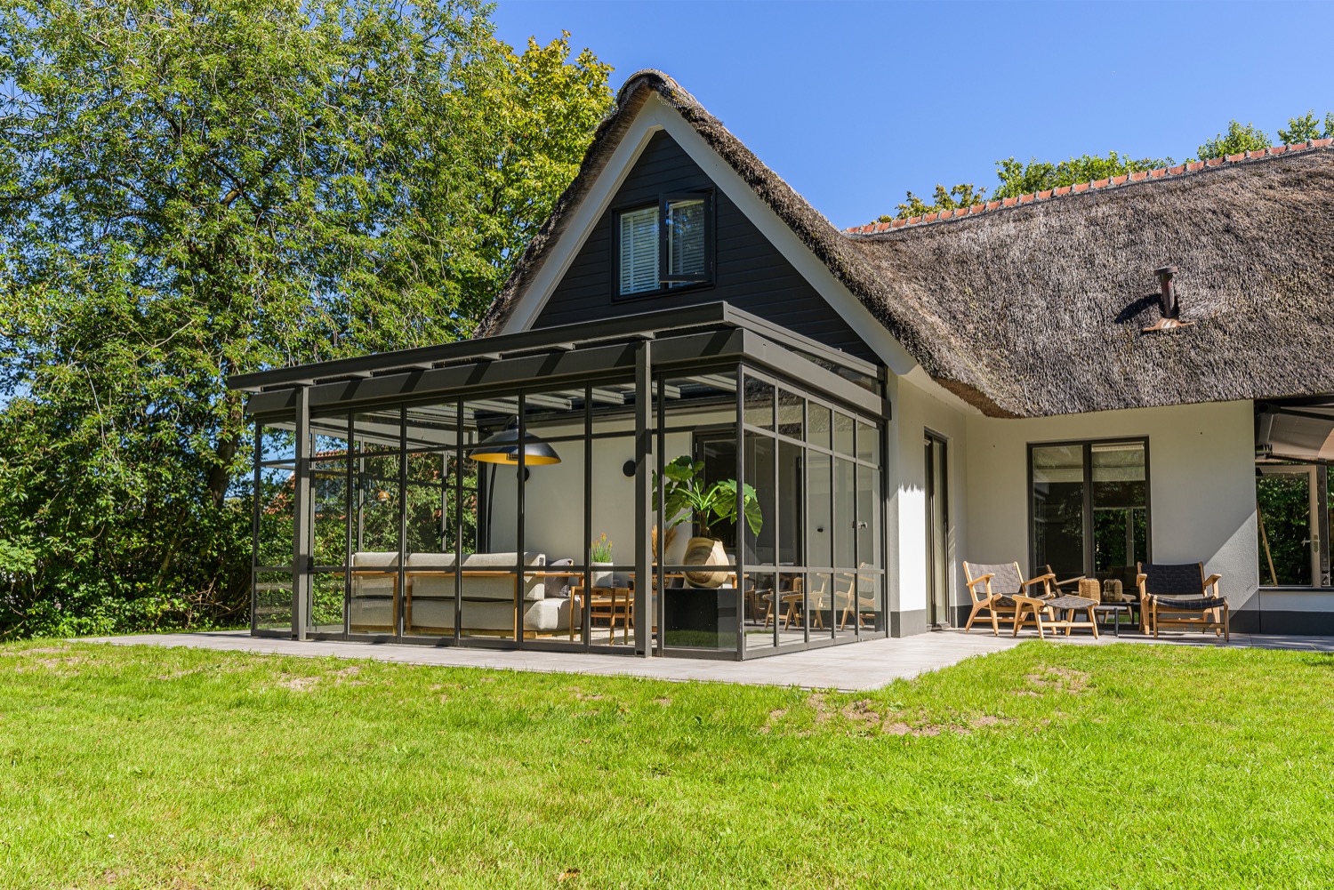 serre bij rietgedekte villa