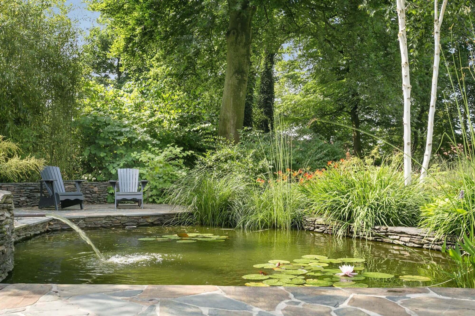 Tuin met vijver en meubels