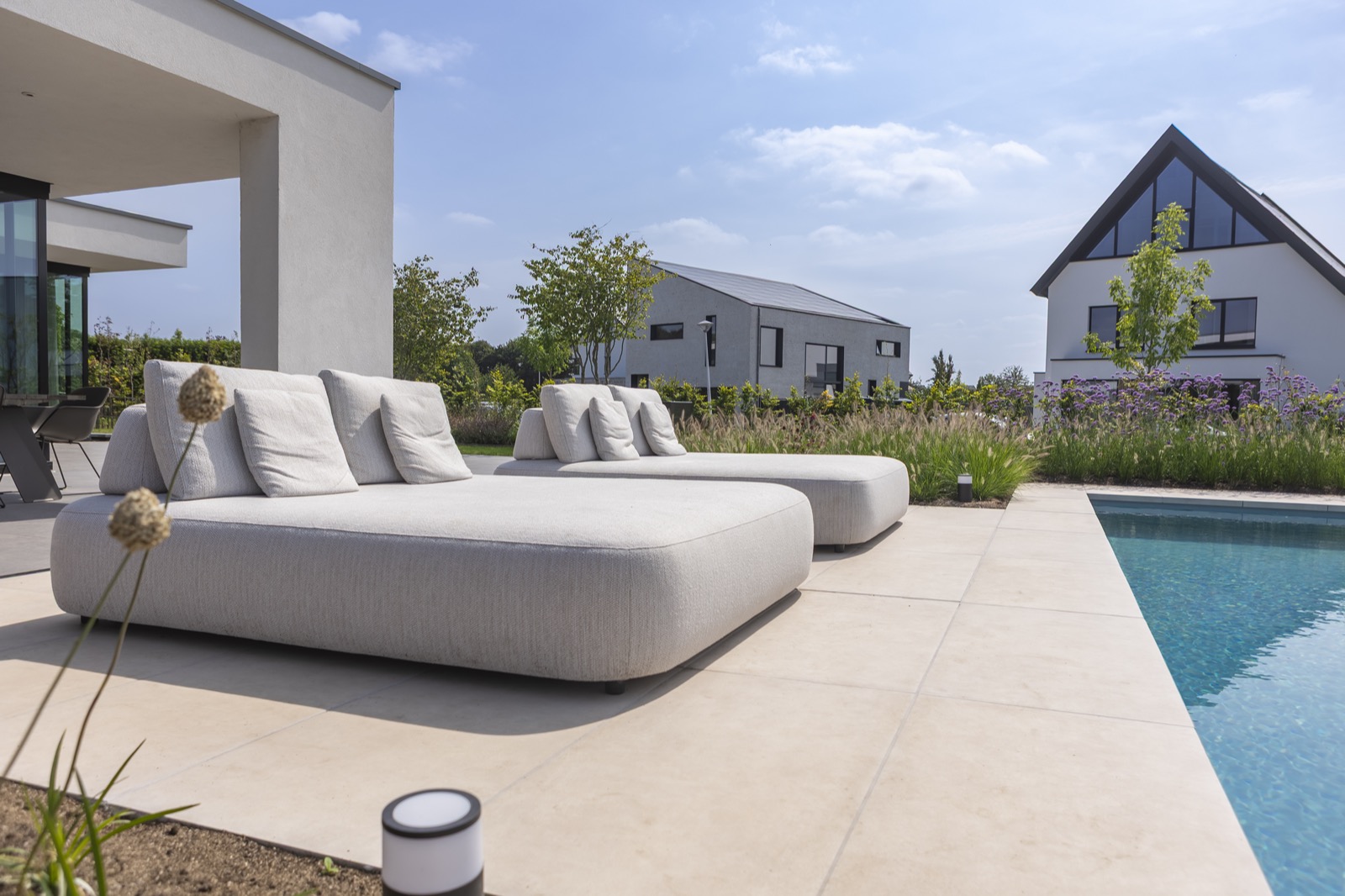 tuin met zwembad en loungestoelen