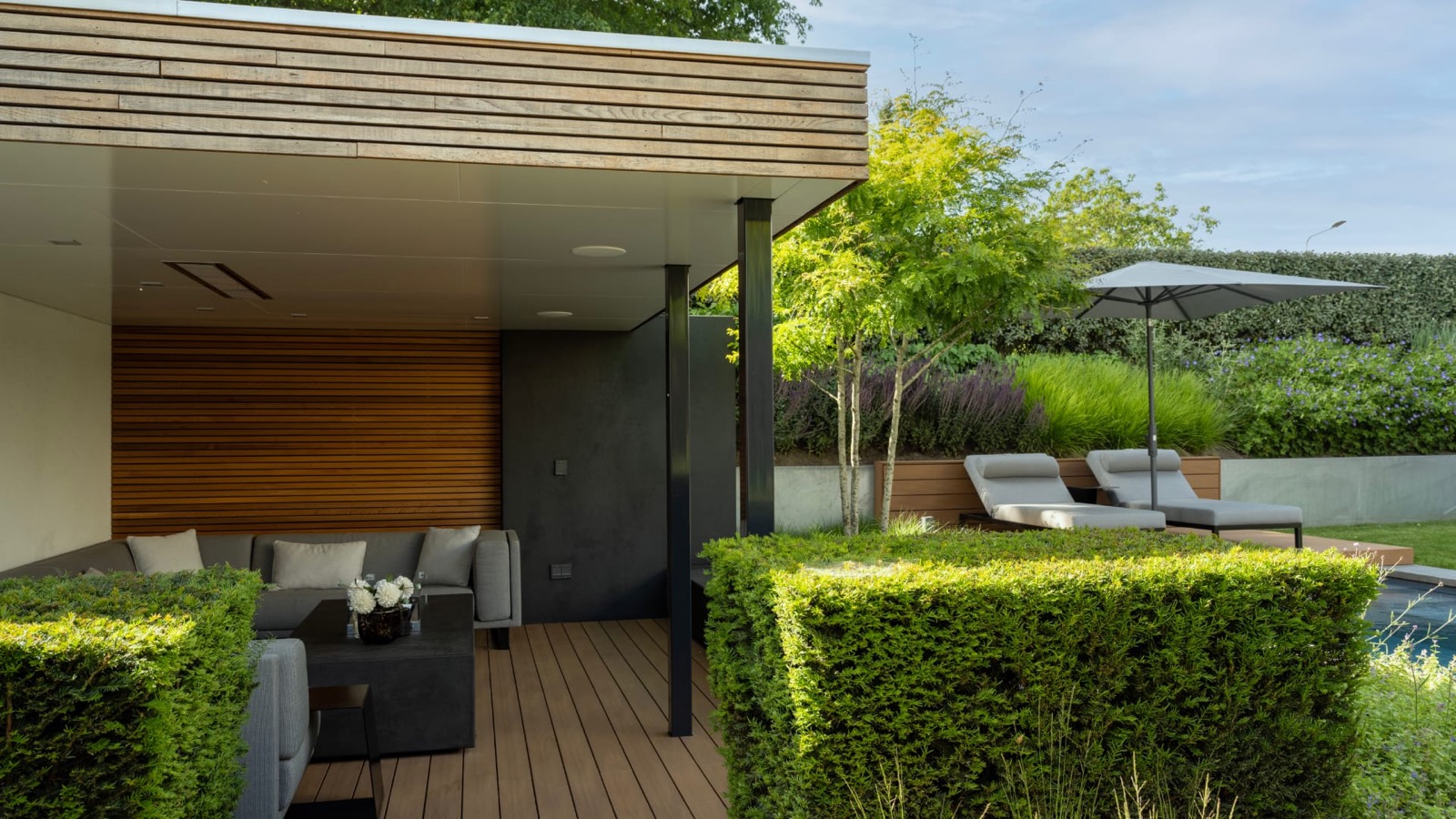 tuin met luxe zwembad en overkapping