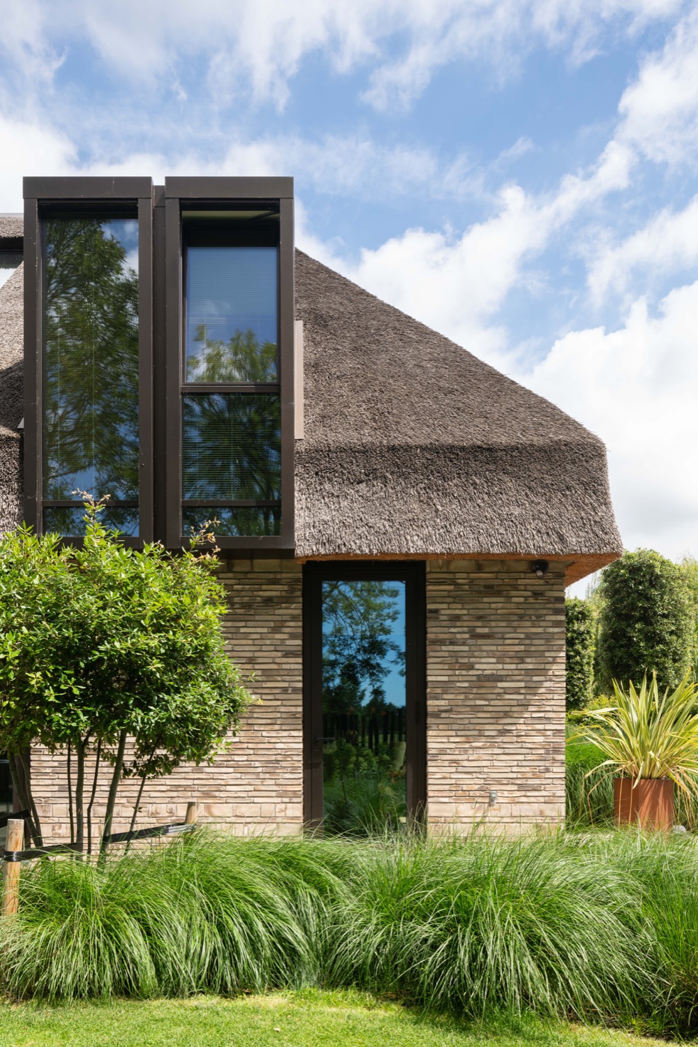 rietgedekte villa met ramen in dak