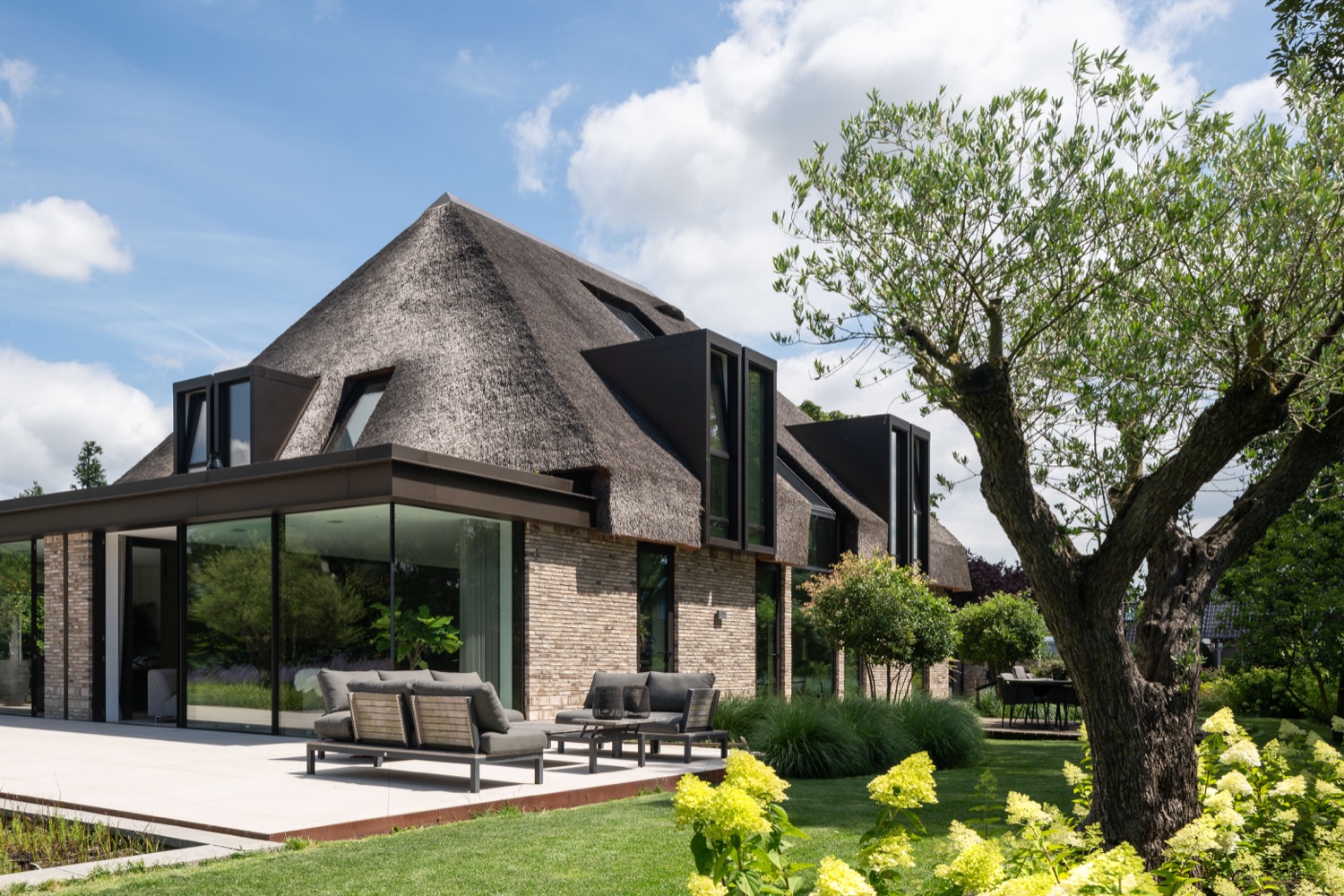 terras bij rietgedekte villa