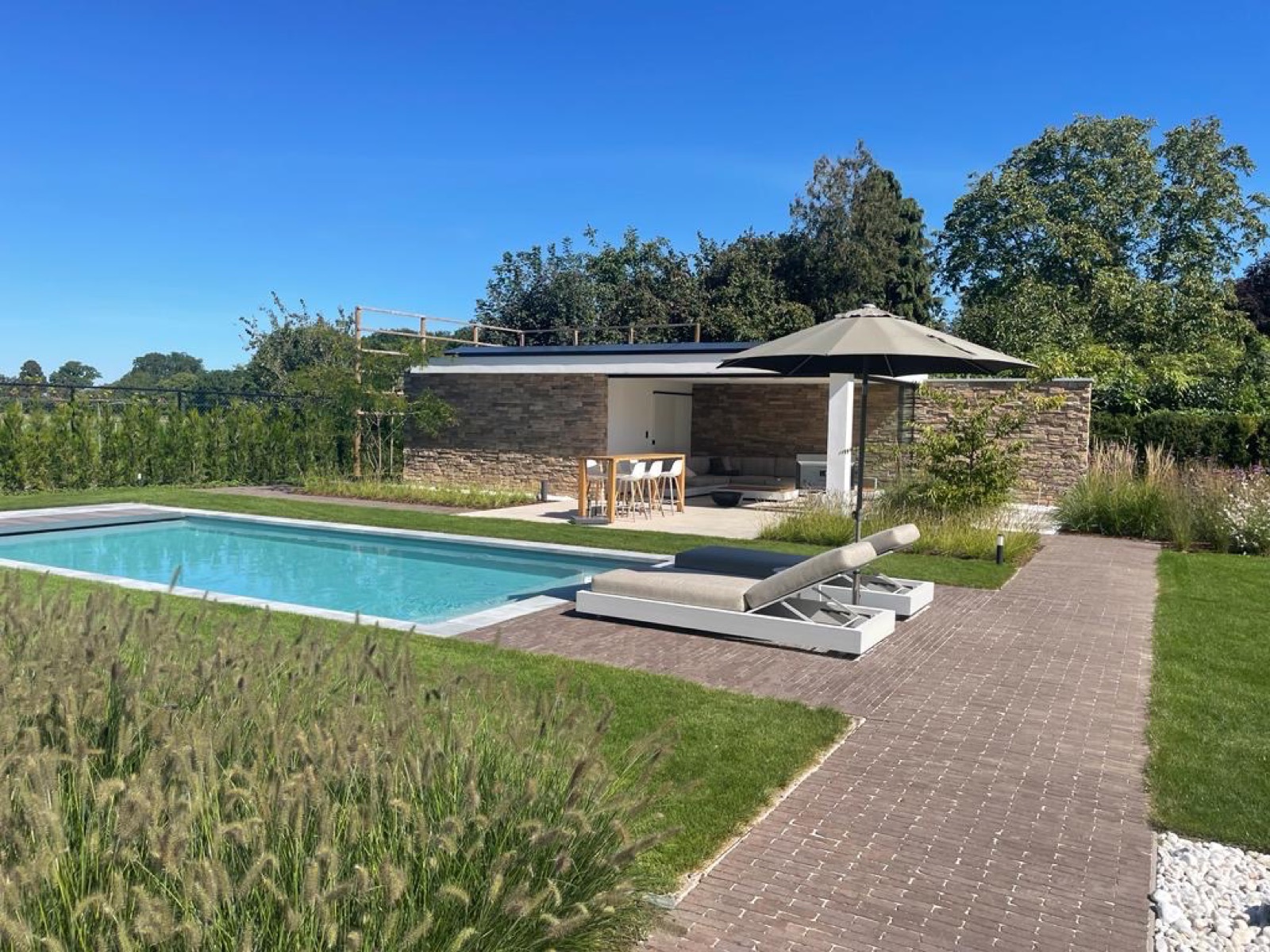 tuin met poolhouse met luxe steenstrips