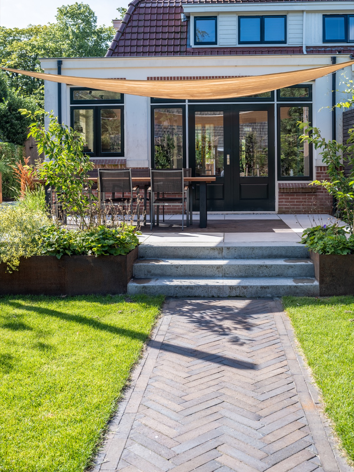 luxe tuin met terras met schaduwdoek