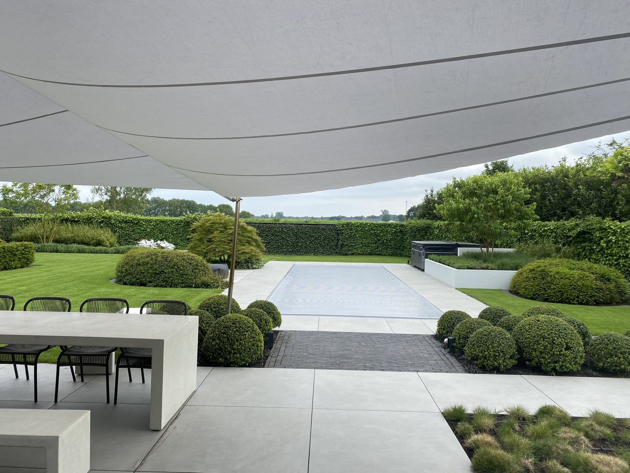 luxe tuin met schaduwzeil en zwembad