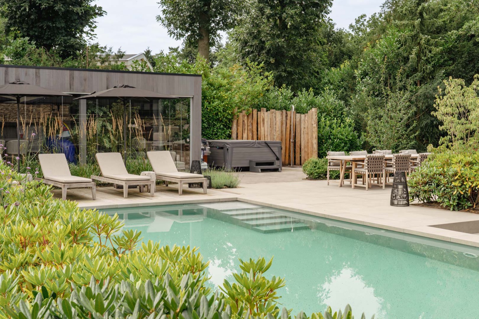 tuin met zwembad en poolhouse en jacuzi