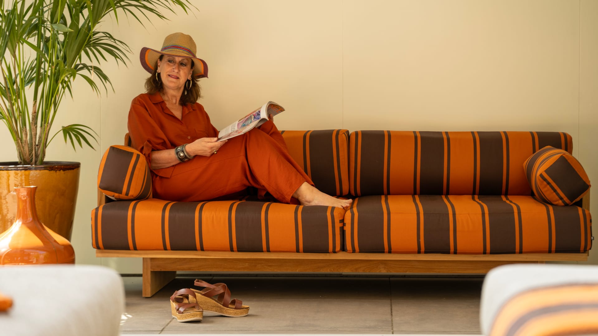 Vrouw relaxed op designbank poolhouse