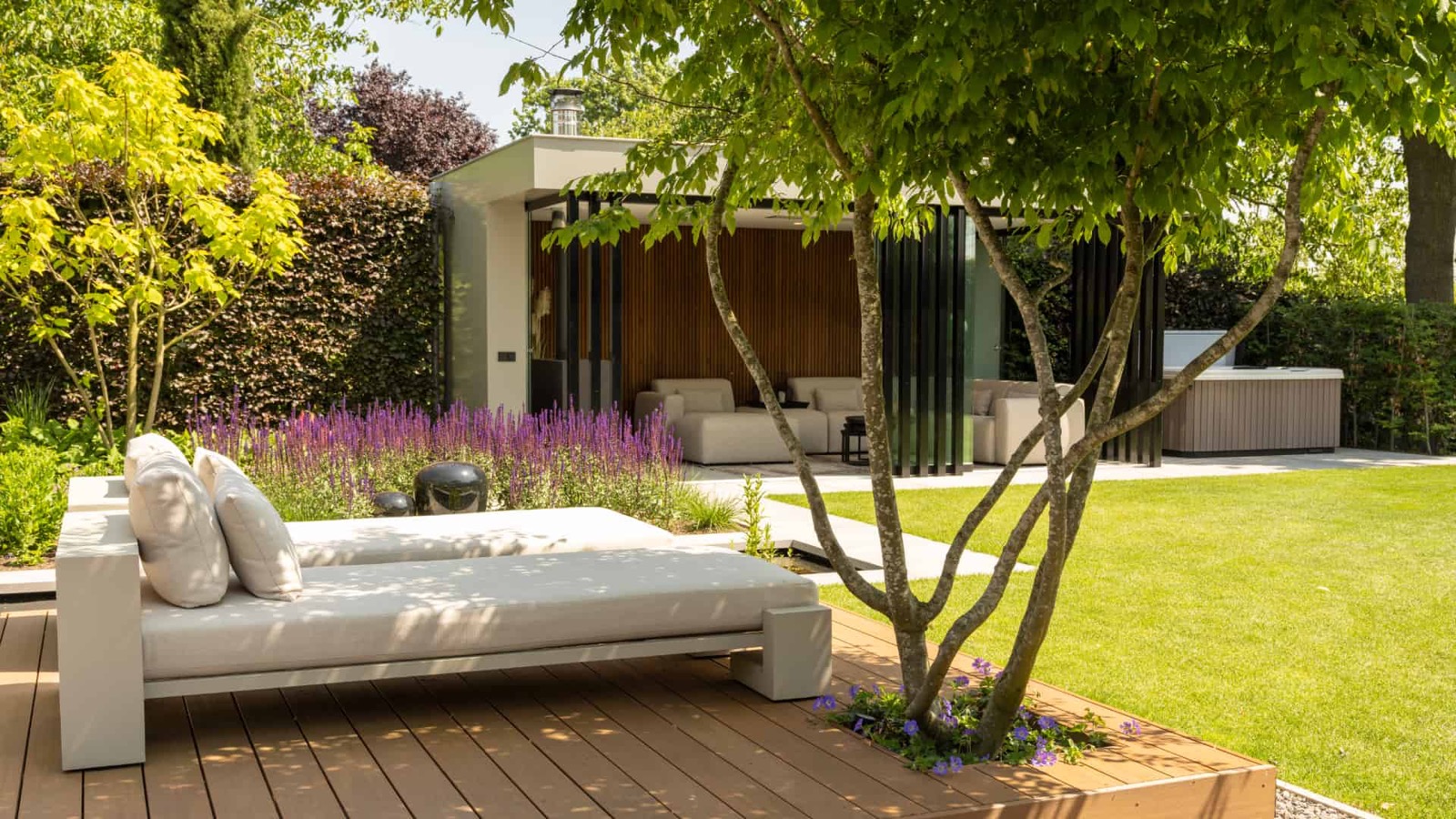 Luxe tuin met meerstammige boom in vlonder