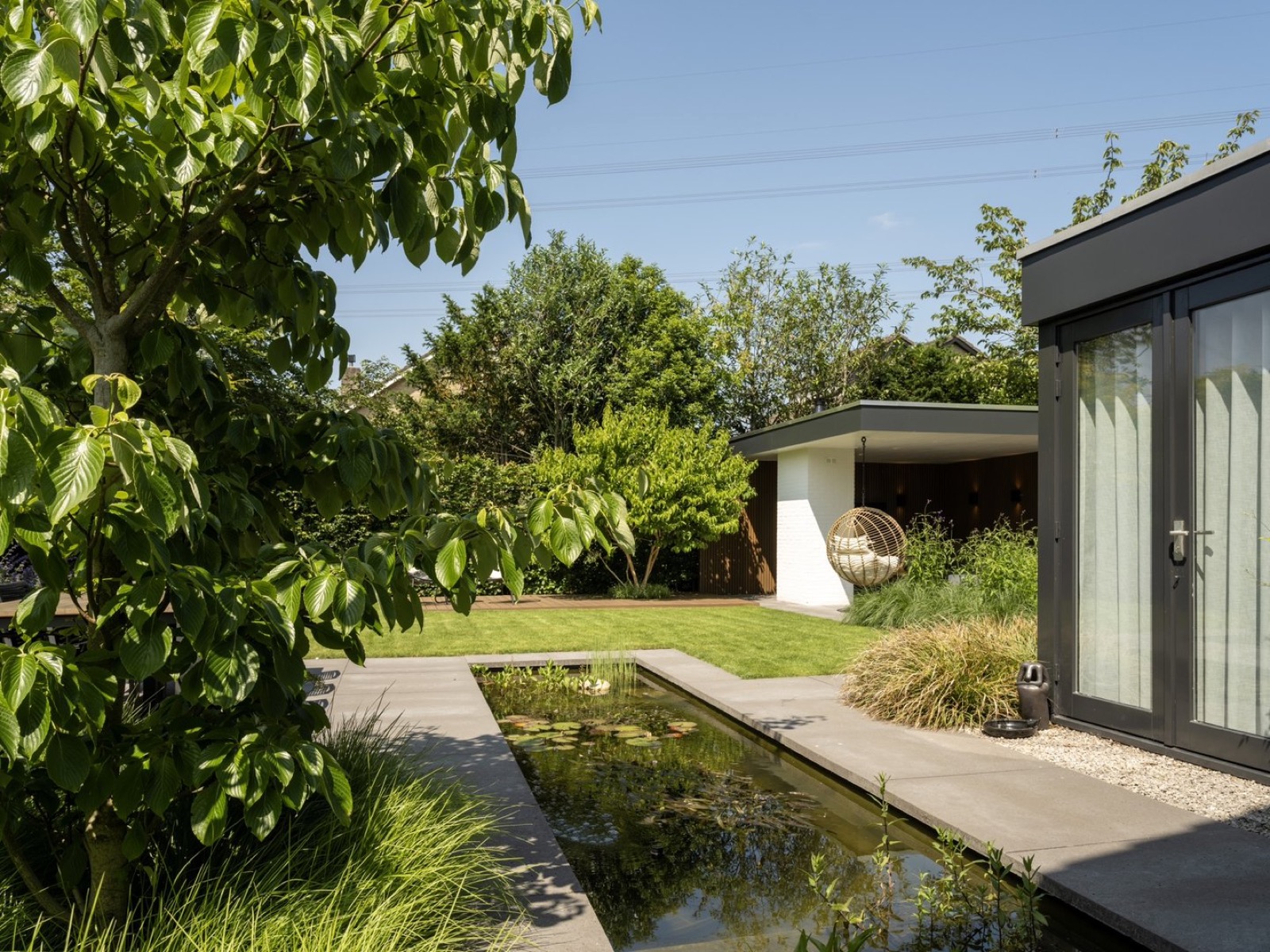 moderne tuin met vijver en overkapping