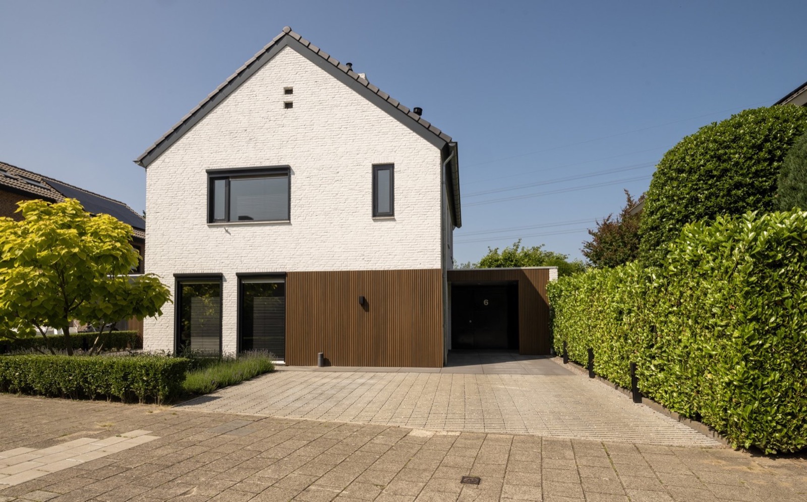 voortuin met witte gevel en houten accenten