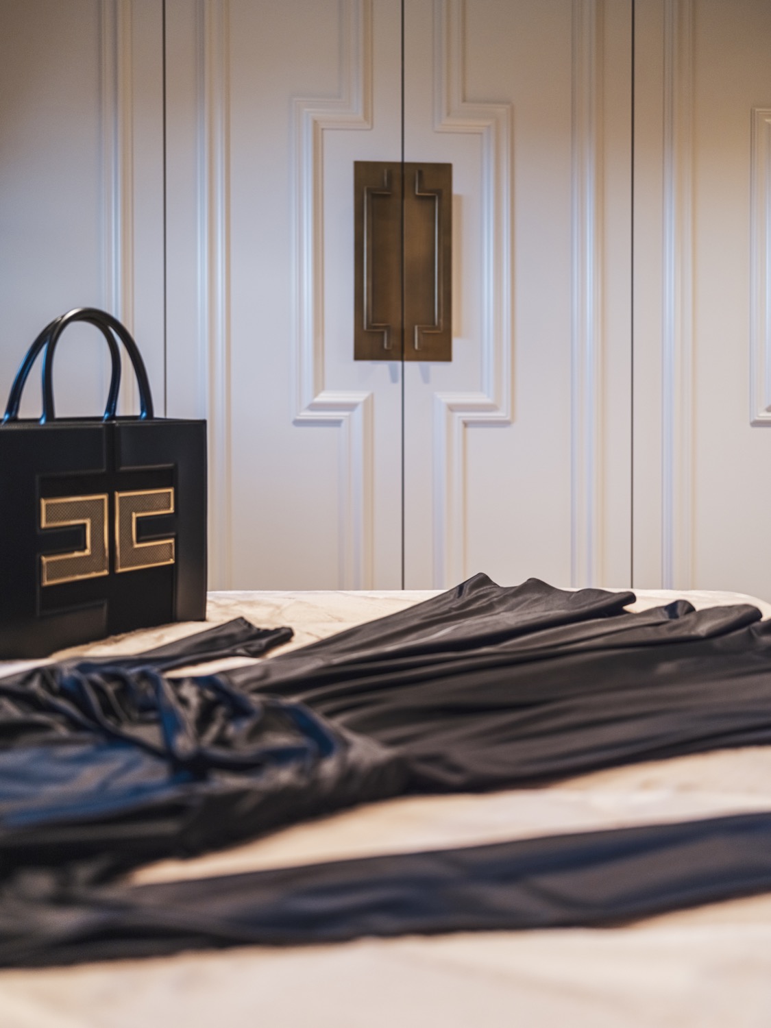 jurk met designtas op bed