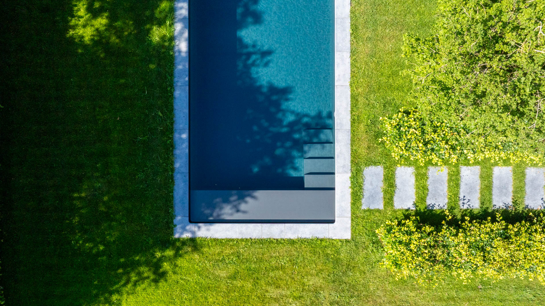 tuin met zwembad en staptegels